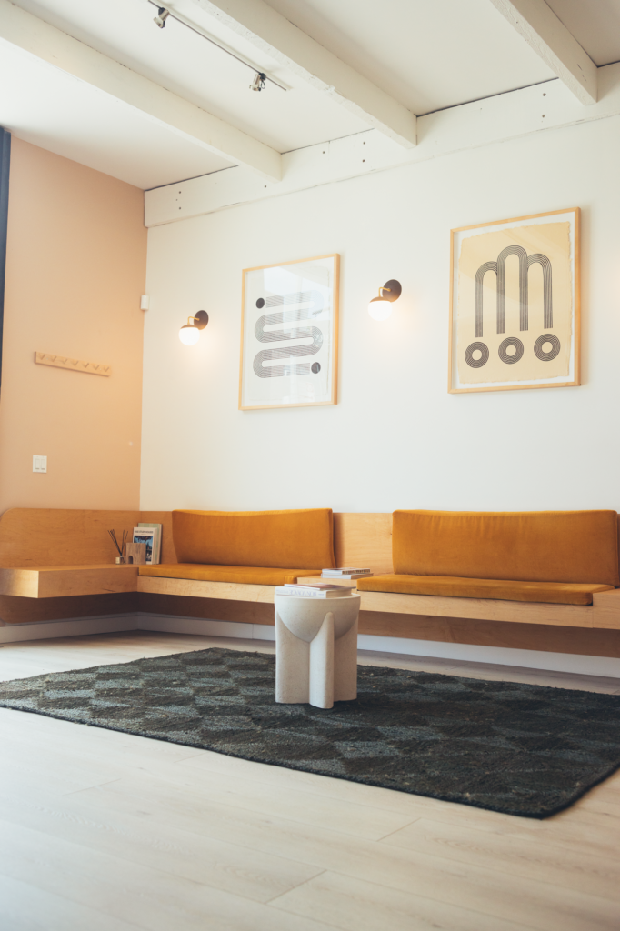 Modern dental office waiting room with warm wood seating, minimalist artwork, and a calm, welcoming design for patient comfort.