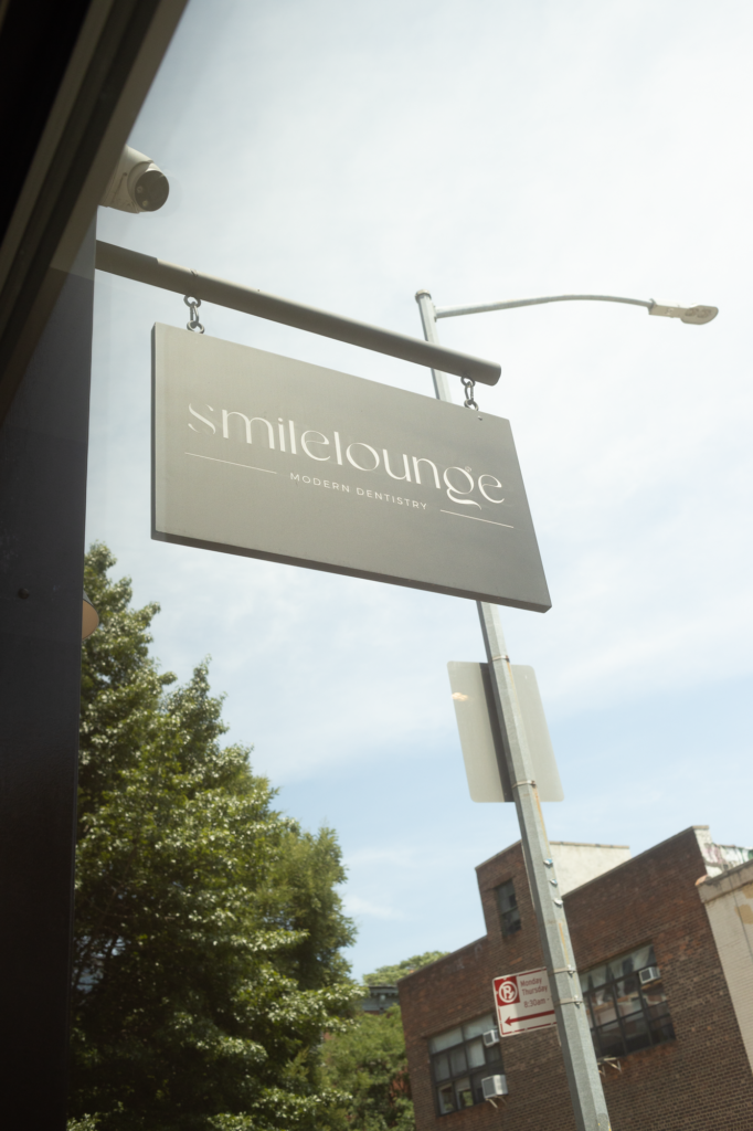 SMILELOUNGE modern dentistry sign hanging outside in Brooklyn, NY