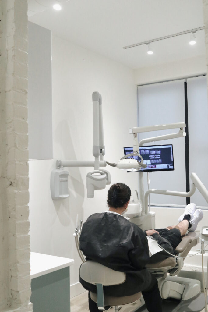 Dentist examining patient with dental X-rays at SMILELOUNGE in Brooklyn, NY